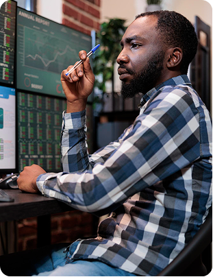 Trader monitoring stocks on multiple screens