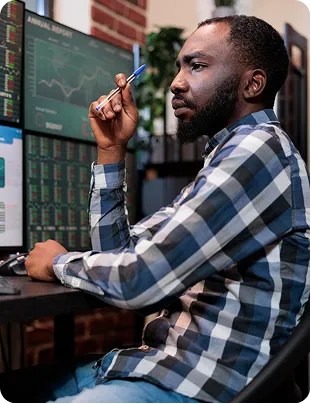 Trader monitoring stocks on multiple screens