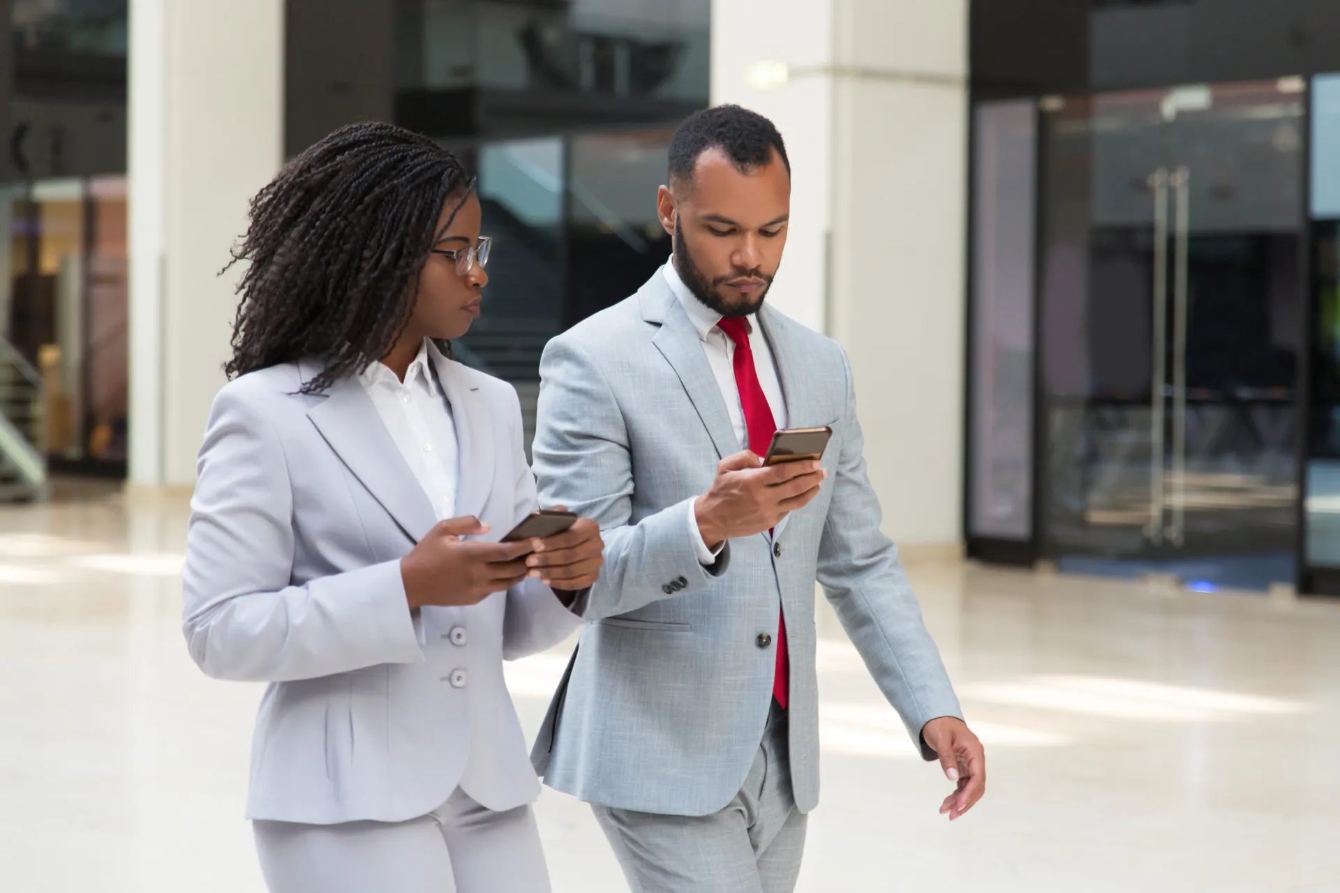 Two professionals reviewing market activity on their phones
