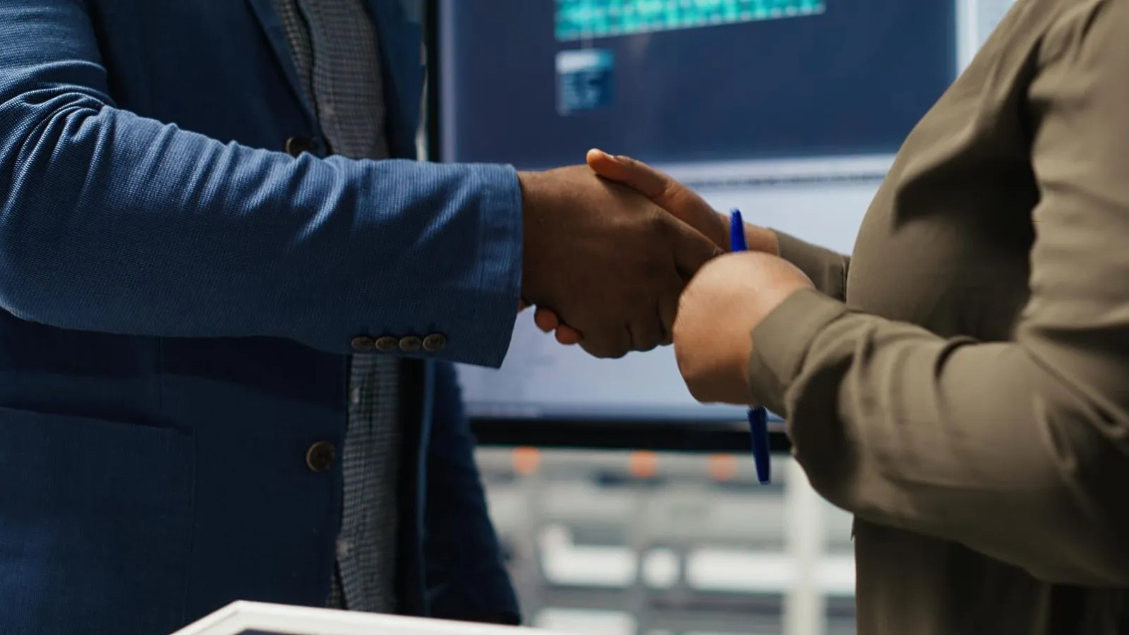 Two professionals shaking hands after a deal