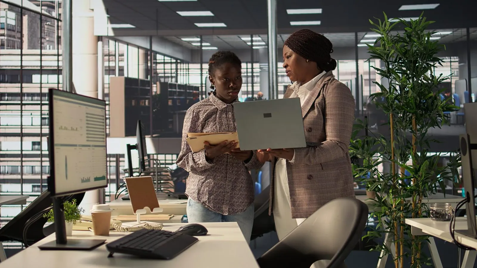 Two colleagues reviewing an offering on a laptop