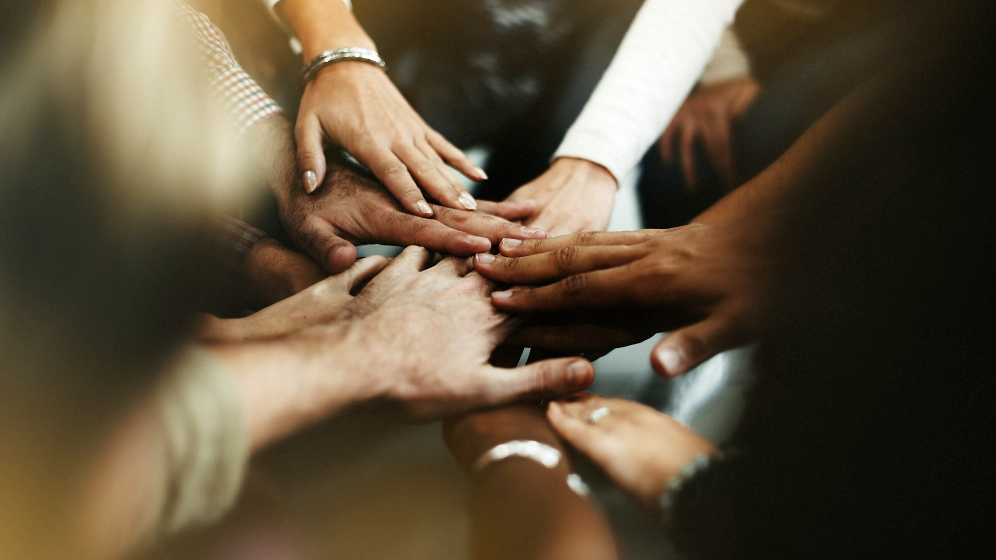 Group of hands joined together symbolising community partnership