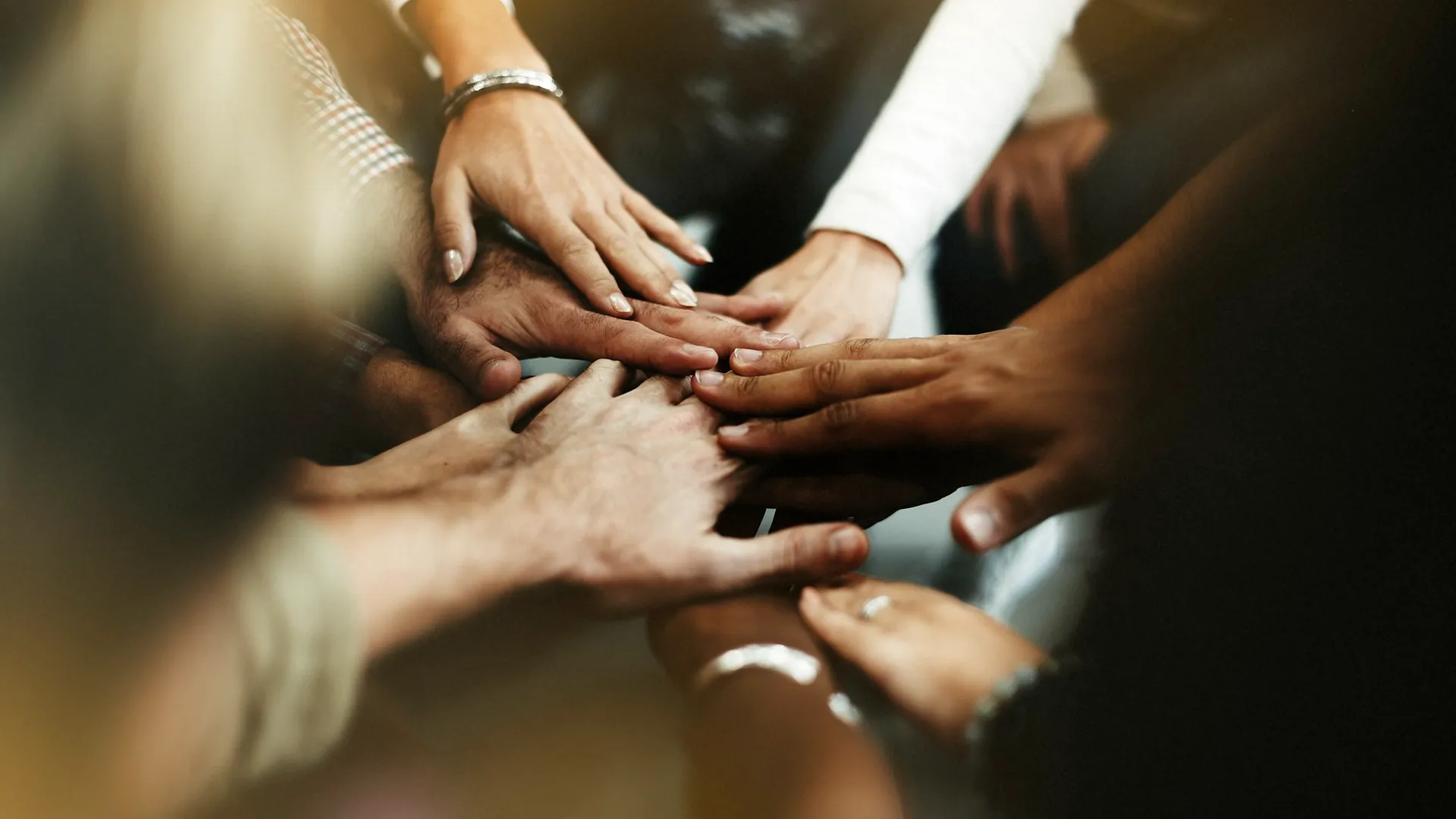 Group of hands joined together symbolising community partnership