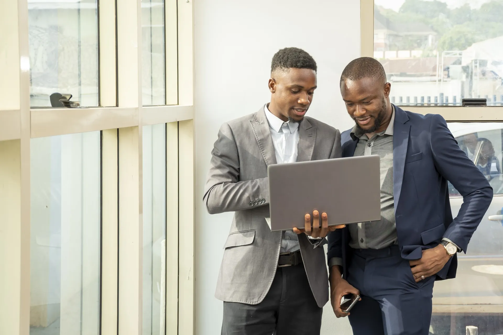 Two professionals collaborating over a laptop